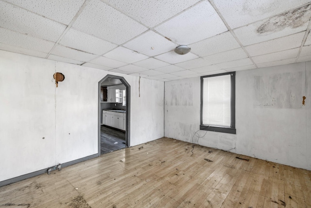 empty room with a paneled ceiling and hardwood / wood-style floors