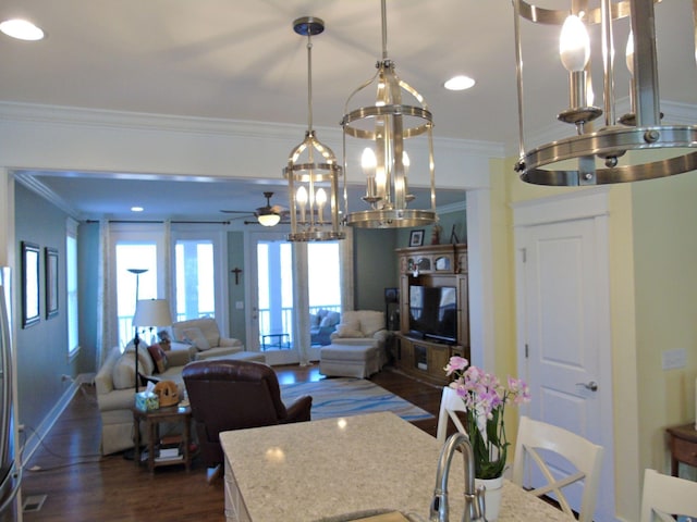 kitchen with pendant lighting, crown molding, dark hardwood / wood-style flooring, and stainless steel fridge