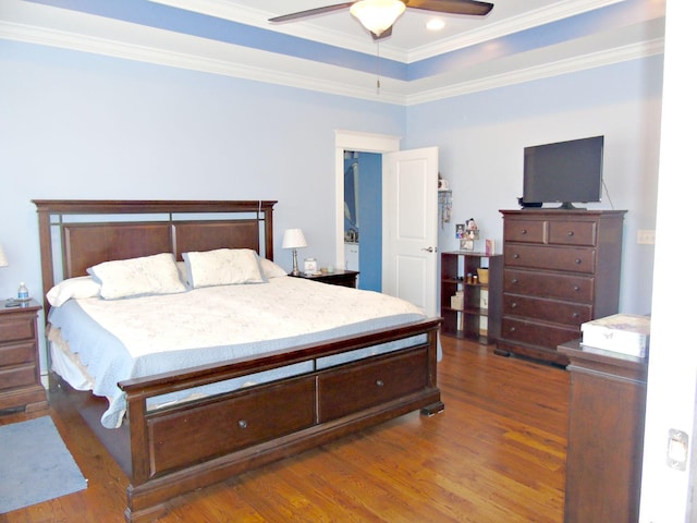 bedroom featuring crown molding, dark wood-type flooring, a raised ceiling, and ceiling fan