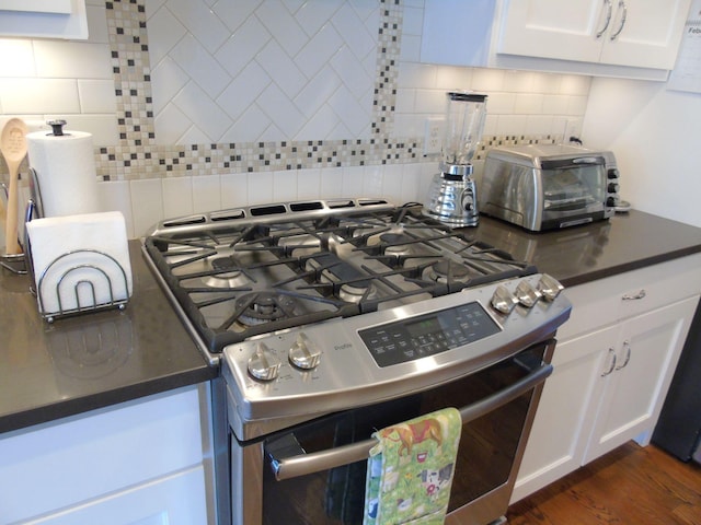 807 Blissfield Ct, Chattanooga, TN 37419 - kitchen featuring stainless steel range with gas stovetop, tasteful backsplash, dark countertops, and white cabinetry