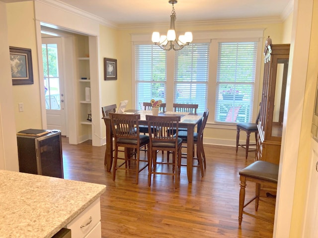 807 Blissfield Ct, Chattanooga, TN 37419 - dining room featuring built in shelves, wood finished floors, a chandelier, ornamental molding, and healthy amount of natural light