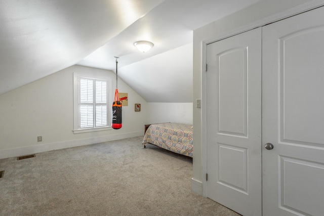 carpeted bedroom featuring a closet and lofted ceiling