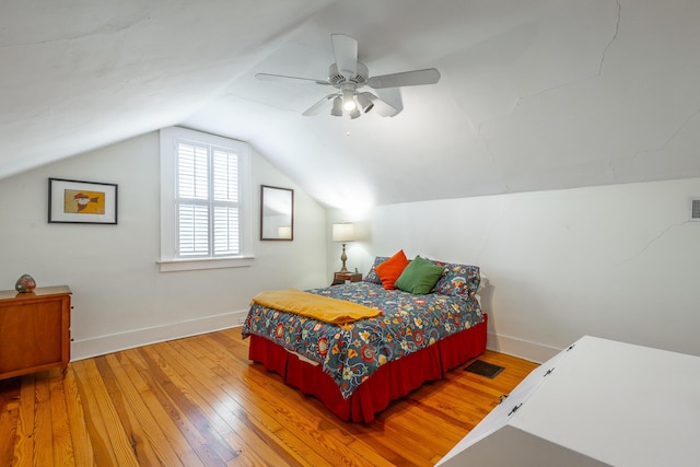 bedroom with ceiling fan, lofted ceiling, and hardwood / wood-style floors