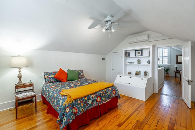 bedroom with ceiling fan, lofted ceiling, hardwood / wood-style floors, and an AC wall unit