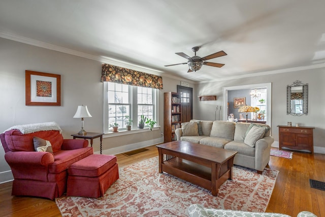 living room featuring ceiling fan, ornamental molding, and wood-type flooring