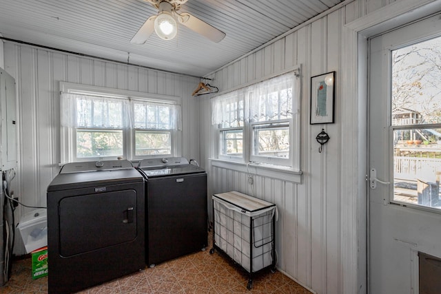 washroom featuring ceiling fan, independent washer and dryer, and wooden walls