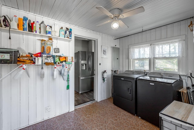 laundry area with washing machine and dryer, ceiling fan, electric panel, and wooden walls