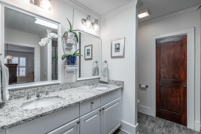 bathroom featuring toilet, vanity, and ornamental molding