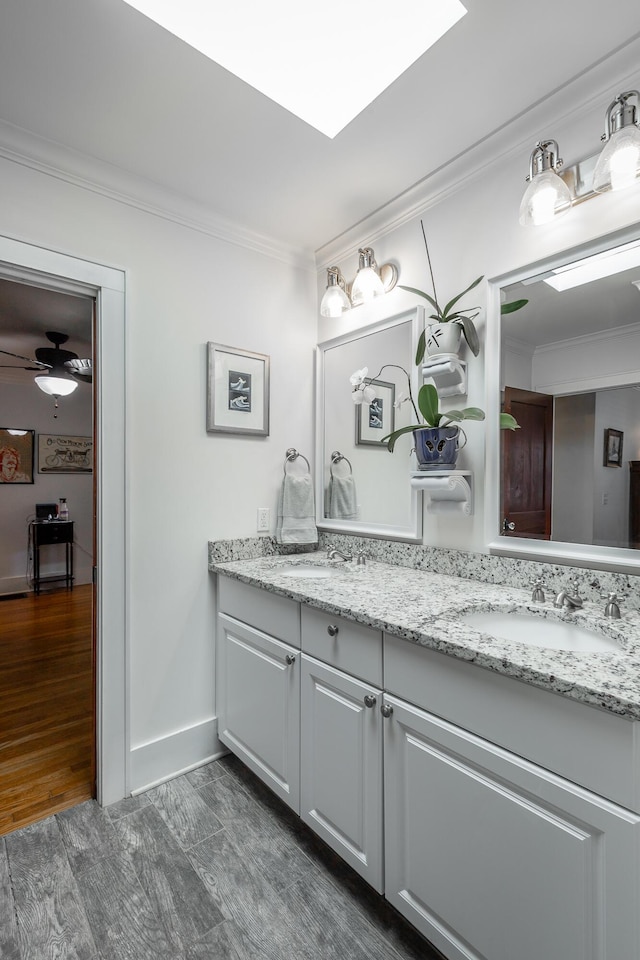 bathroom featuring ceiling fan, vanity, and crown molding