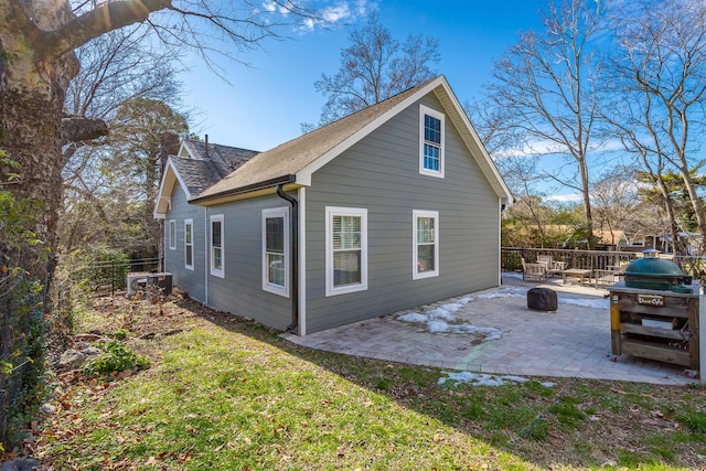 rear view of house with a fire pit and a patio