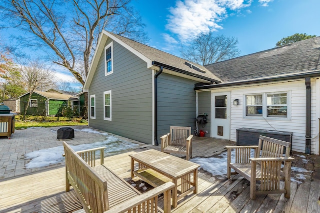 wooden terrace featuring a fire pit and a patio