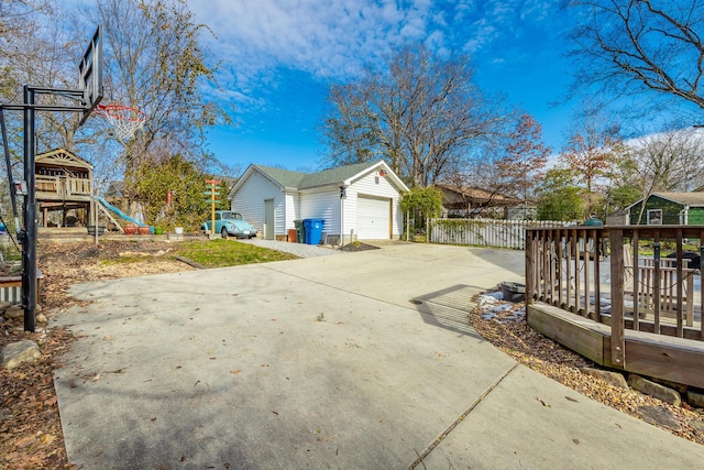 view of side of property with an outbuilding, a garage, a wooden deck, and a playground