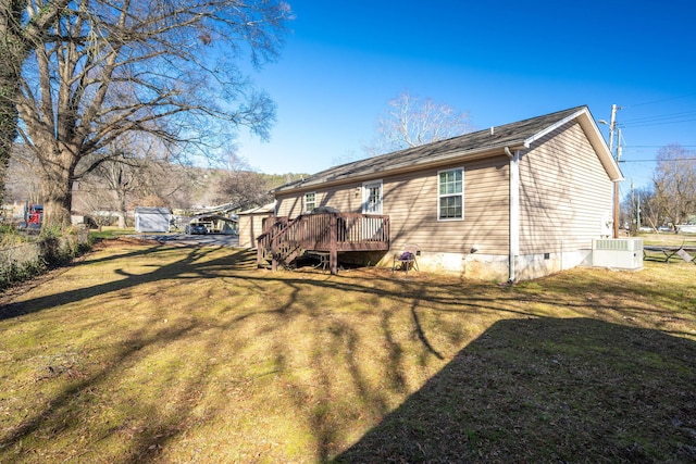 back of property with central AC, a yard, and a wooden deck