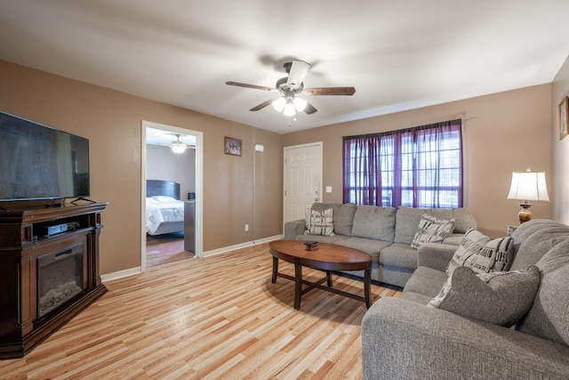 living room with ceiling fan and light wood-type flooring