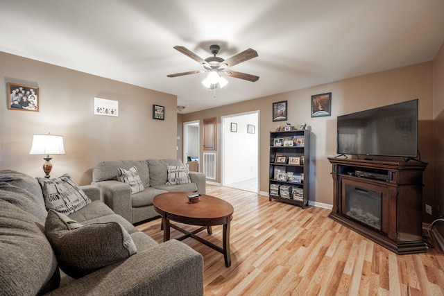 living room with light hardwood / wood-style floors and ceiling fan