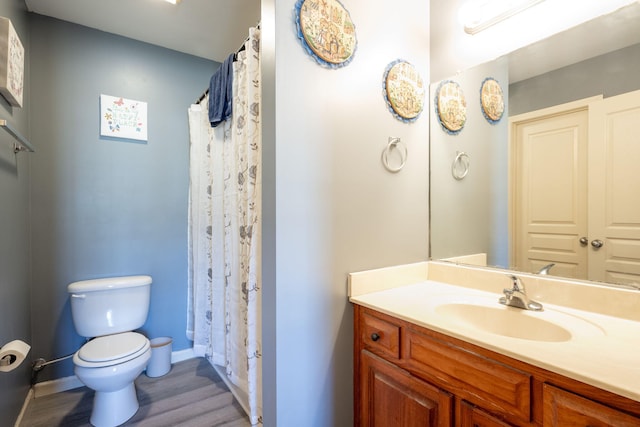 bathroom with hardwood / wood-style floors, vanity, toilet, and a shower with curtain