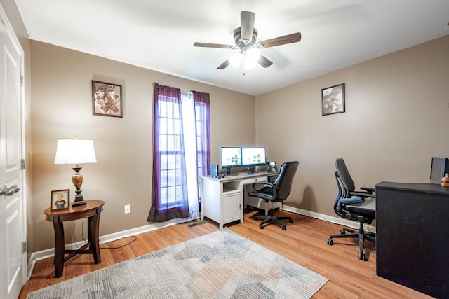 office featuring light hardwood / wood-style floors, ceiling fan, and a healthy amount of sunlight