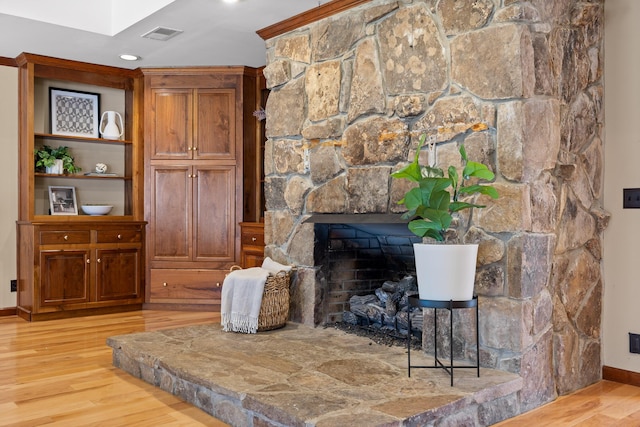 living room featuring a stone fireplace and light hardwood / wood-style flooring