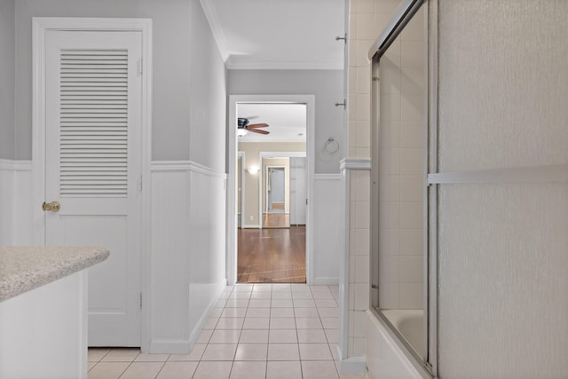 bathroom with tile patterned floors, bath / shower combo with glass door, ornamental molding, vanity, and ceiling fan