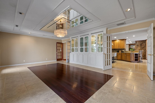 living room with ornamental molding, light tile patterned floors, a notable chandelier, and french doors