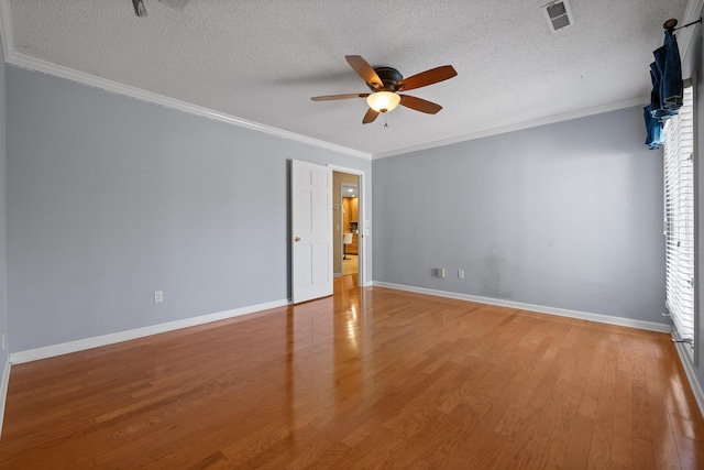 unfurnished room featuring crown molding, a textured ceiling, and light wood-type flooring