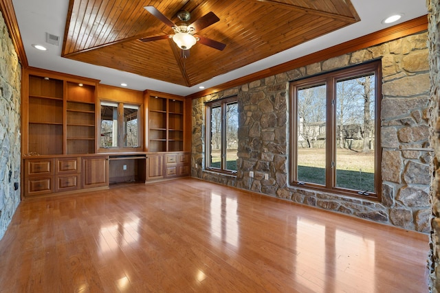 unfurnished living room with wood ceiling, light hardwood / wood-style flooring, ceiling fan, built in desk, and a raised ceiling