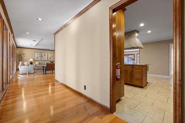 hall with ornamental molding and light wood-type flooring