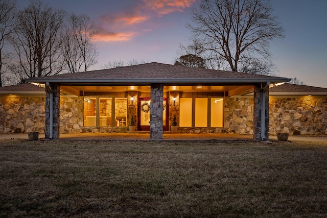 back house at dusk with a yard