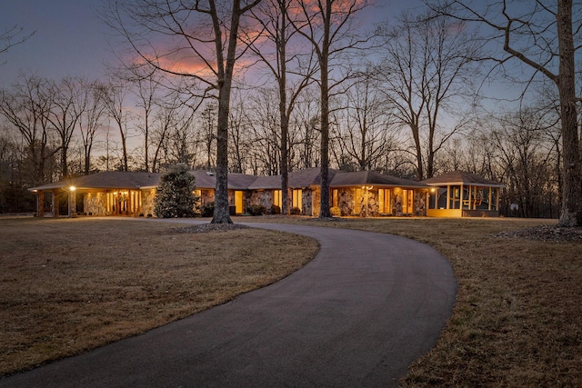 view of front of house featuring a sunroom and a lawn