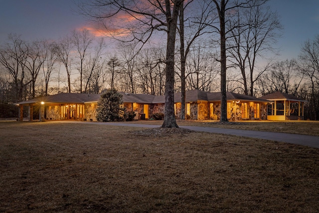 view of front of property with a sunroom and a yard