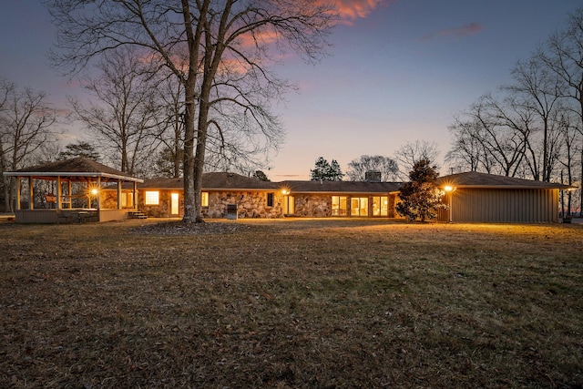 view of front of property featuring a gazebo and a lawn