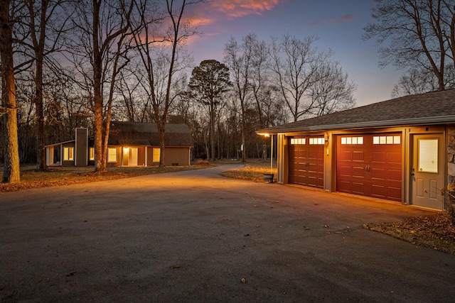 view of garage at dusk