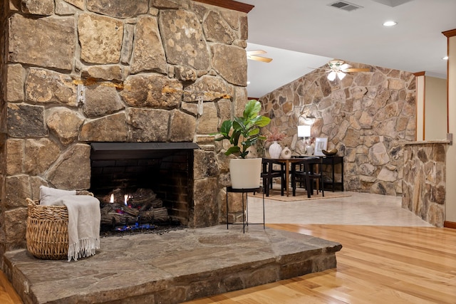 room details with hardwood / wood-style floors, a stone fireplace, and ceiling fan