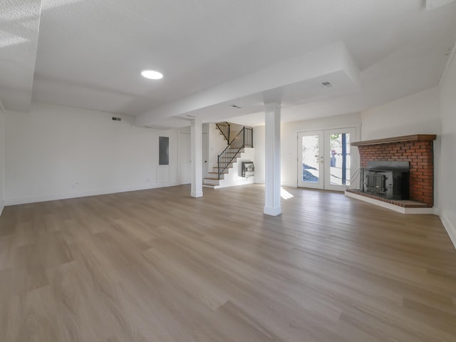 unfurnished living room with light hardwood / wood-style floors, french doors, and electric panel