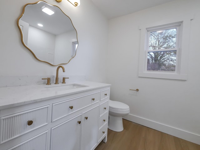 bathroom featuring wood-type flooring, vanity, and toilet