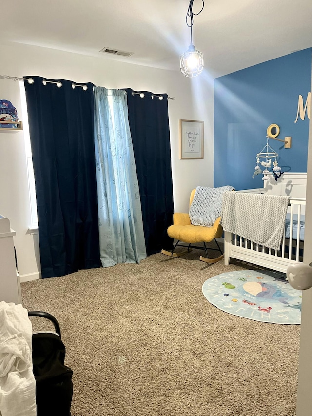 bedroom featuring carpet floors and a crib