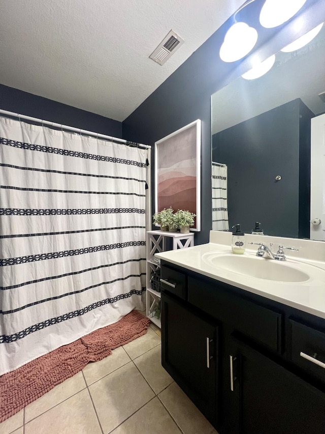 bathroom with vanity, a textured ceiling, and tile patterned floors