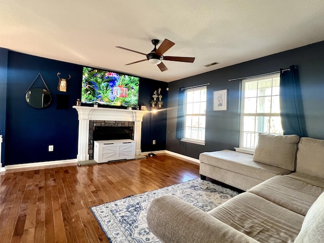 living room with a fireplace, ceiling fan, and hardwood / wood-style floors