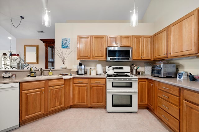 kitchen with white appliances, pendant lighting, and sink