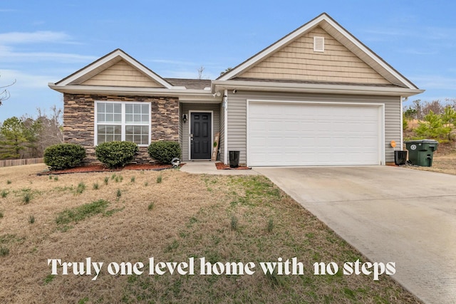 single story home with a garage, a front yard, stone siding, and driveway