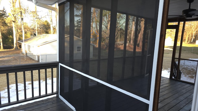 deck with ceiling fan and a sunroom