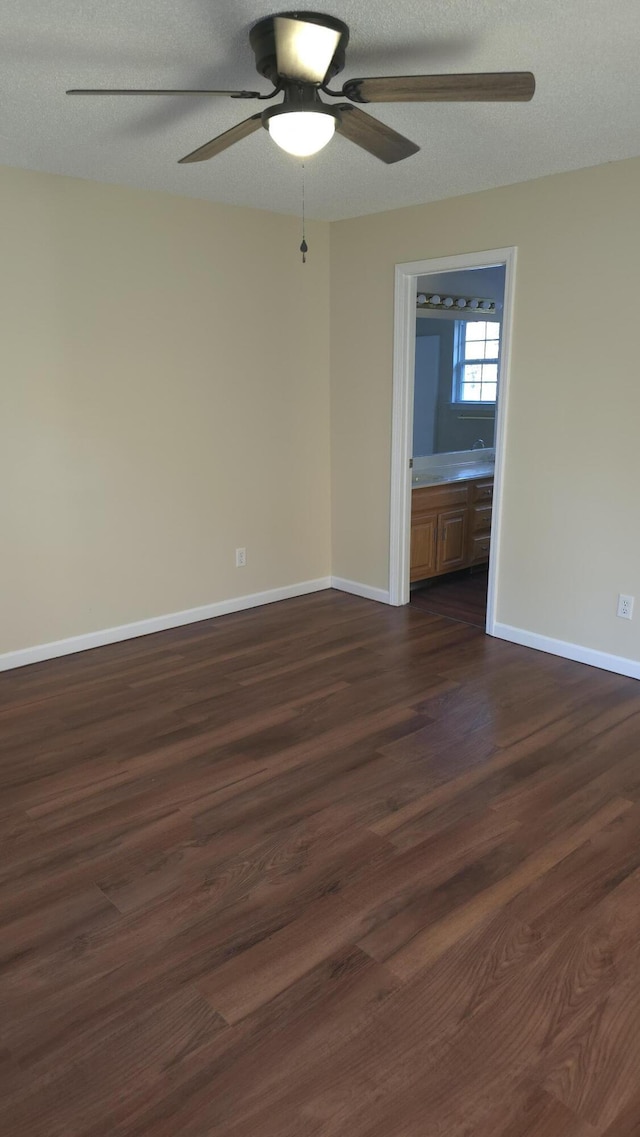 empty room featuring a textured ceiling, dark hardwood / wood-style flooring, and ceiling fan