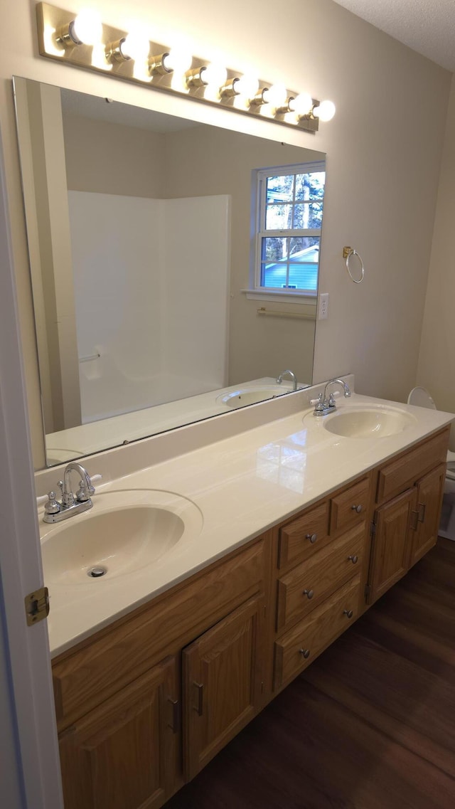 bathroom featuring toilet, hardwood / wood-style flooring, and vanity