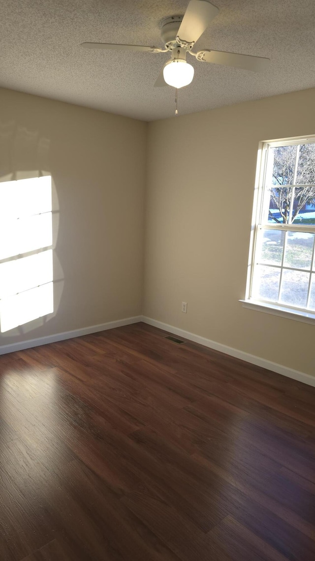 unfurnished room featuring a textured ceiling, dark wood-type flooring, and ceiling fan