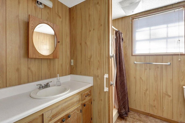 bathroom featuring walk in shower, vanity, and wooden walls