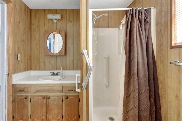 bathroom featuring a shower with curtain, vanity, and wooden walls