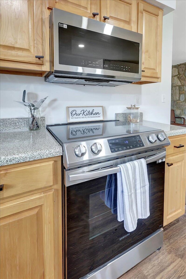 kitchen featuring appliances with stainless steel finishes, light brown cabinetry, and light hardwood / wood-style floors