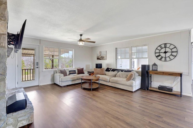 living room featuring ceiling fan, crown molding, hardwood / wood-style floors, and a textured ceiling