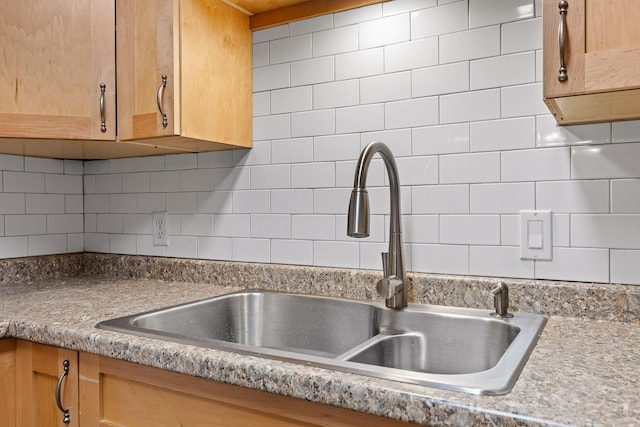 kitchen featuring sink and backsplash