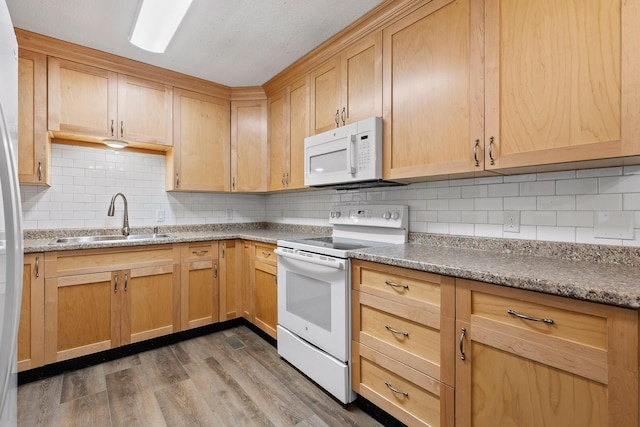 kitchen featuring sink, stone counters, white appliances, tasteful backsplash, and dark wood-type flooring